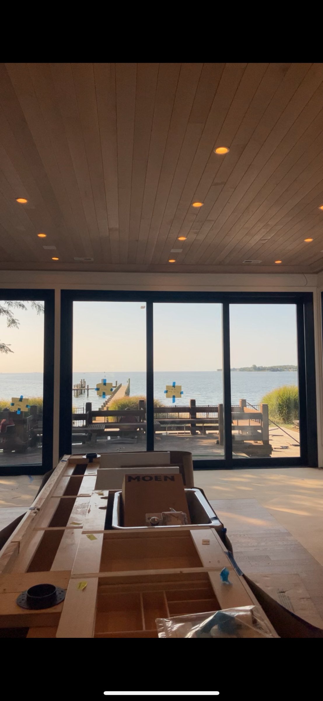 Waterfront great room: wood ceiling with recessed lighting and a glass wall to the dock